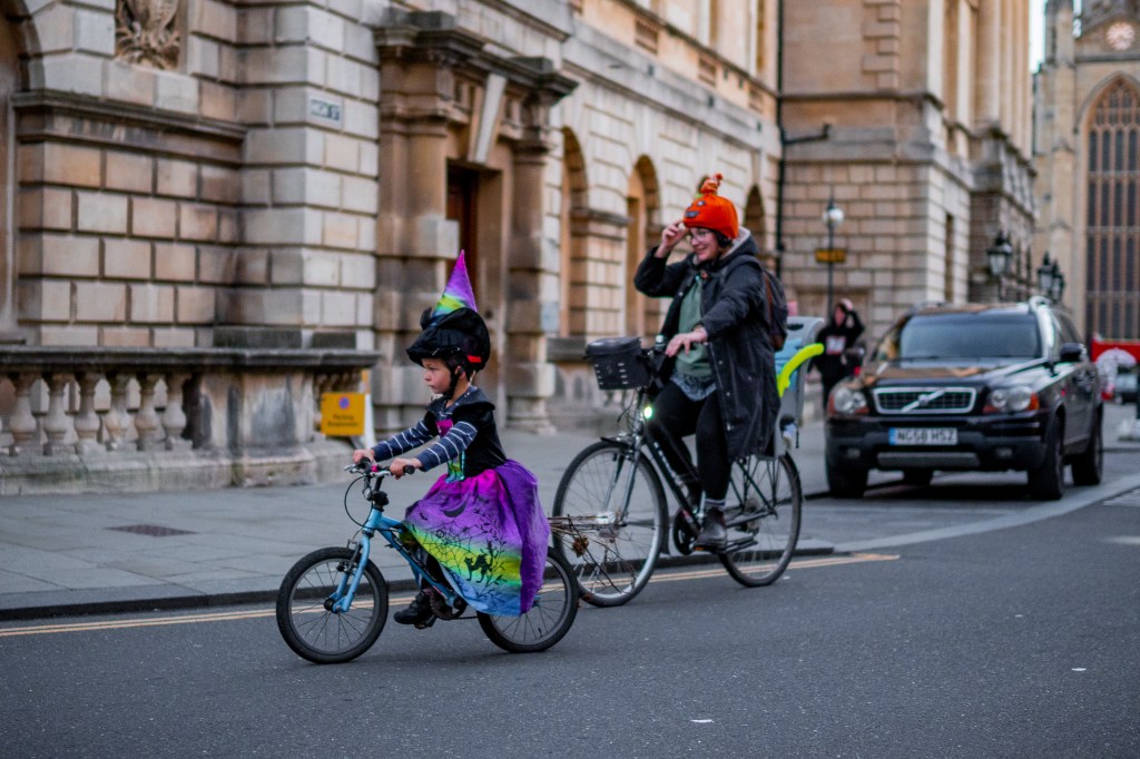 Parent and child cycling in Halloween outfits