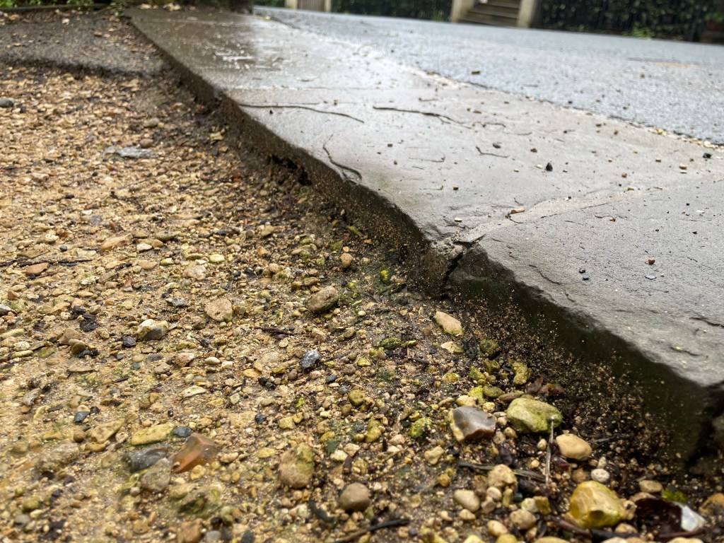 Self binding gravel shown next to a paving slab showing the surface is not level.